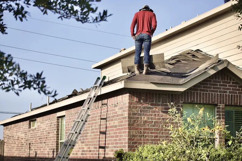 Professional roofer working on a residential roof in Coweta